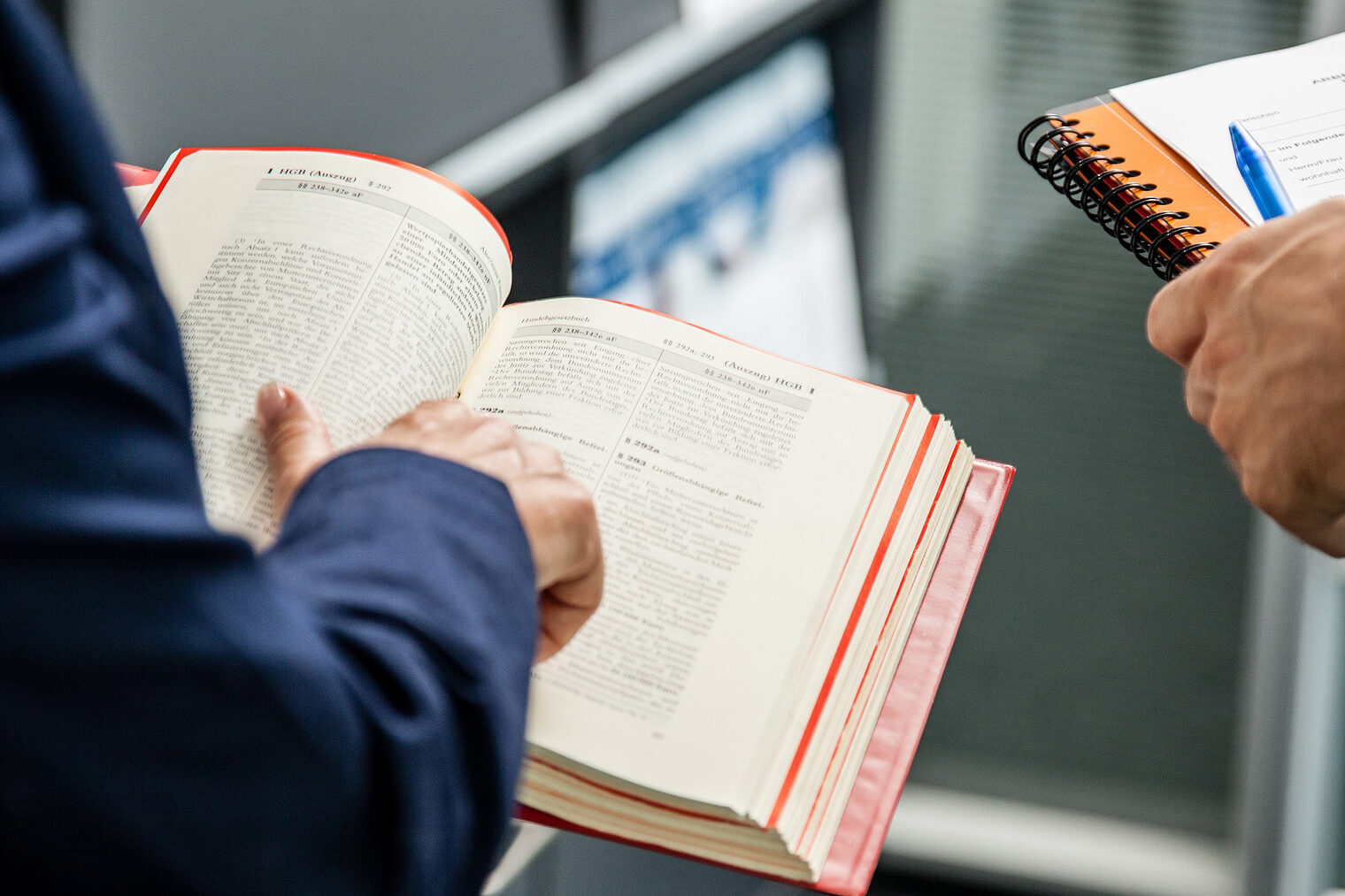 In den Händen eines Mannes ein offenes Gesetzbuch