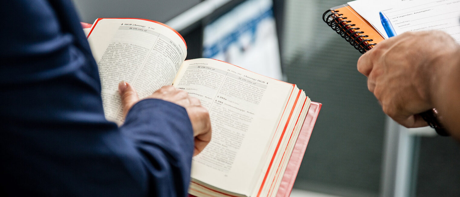 In den Händen eines Mannes ein offenes Gesetzbuch