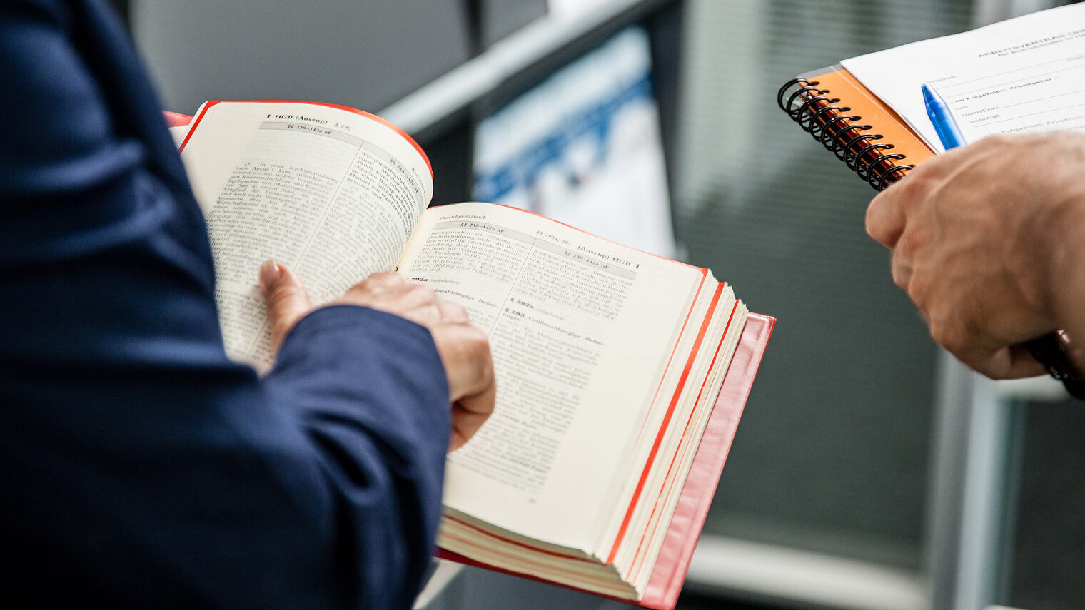 In den Händen eines Mannes ein offenes Gesetzbuch