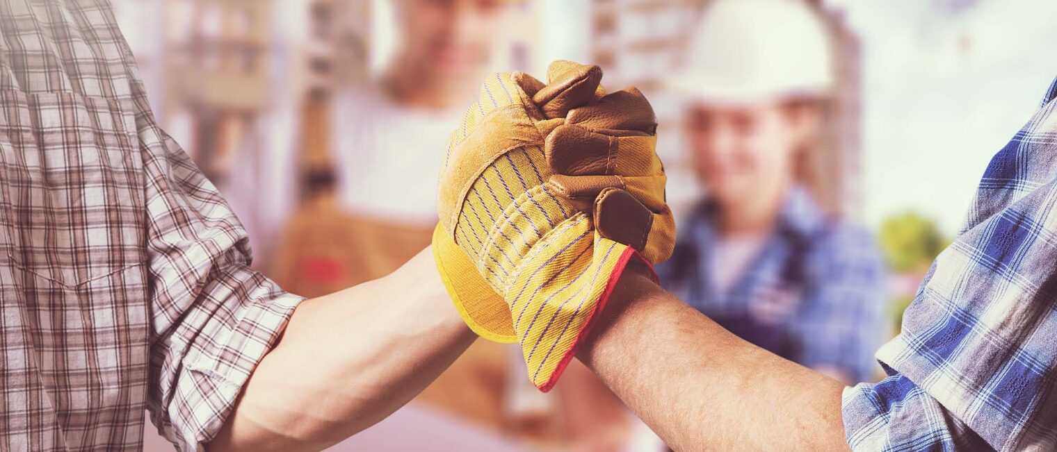 Zwei behandschuhte Hände schlagen ein