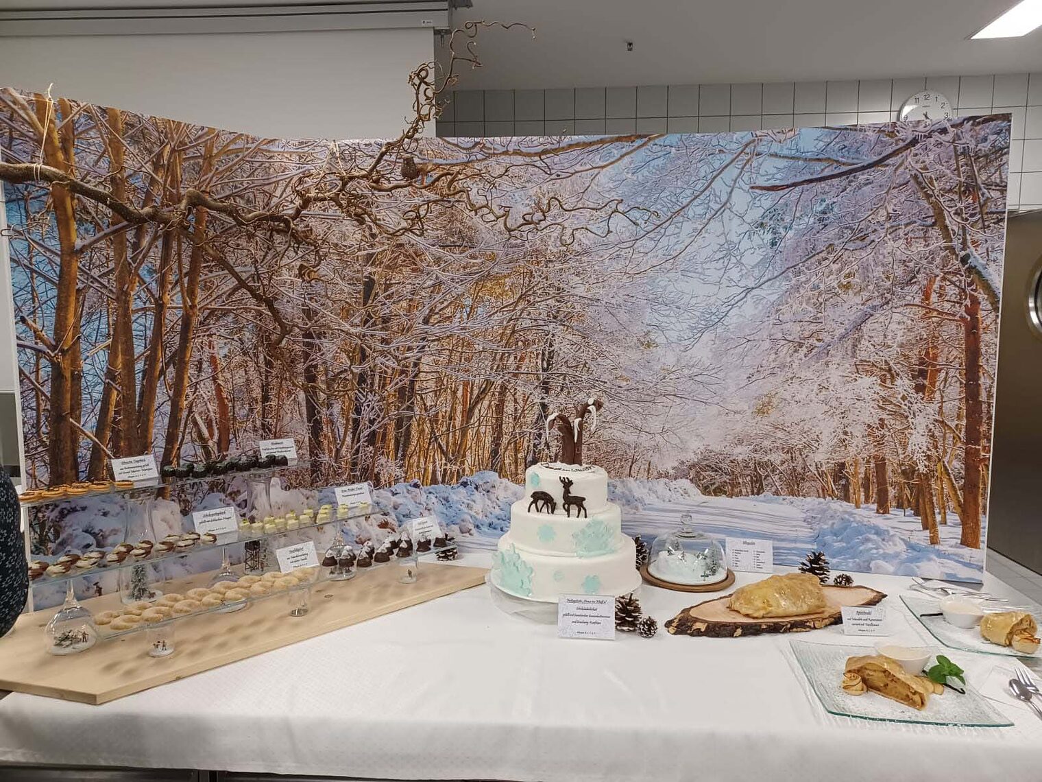 Aufbau von Torten und Gebäck auf einem Tisch vor winterlichem Hintergrund