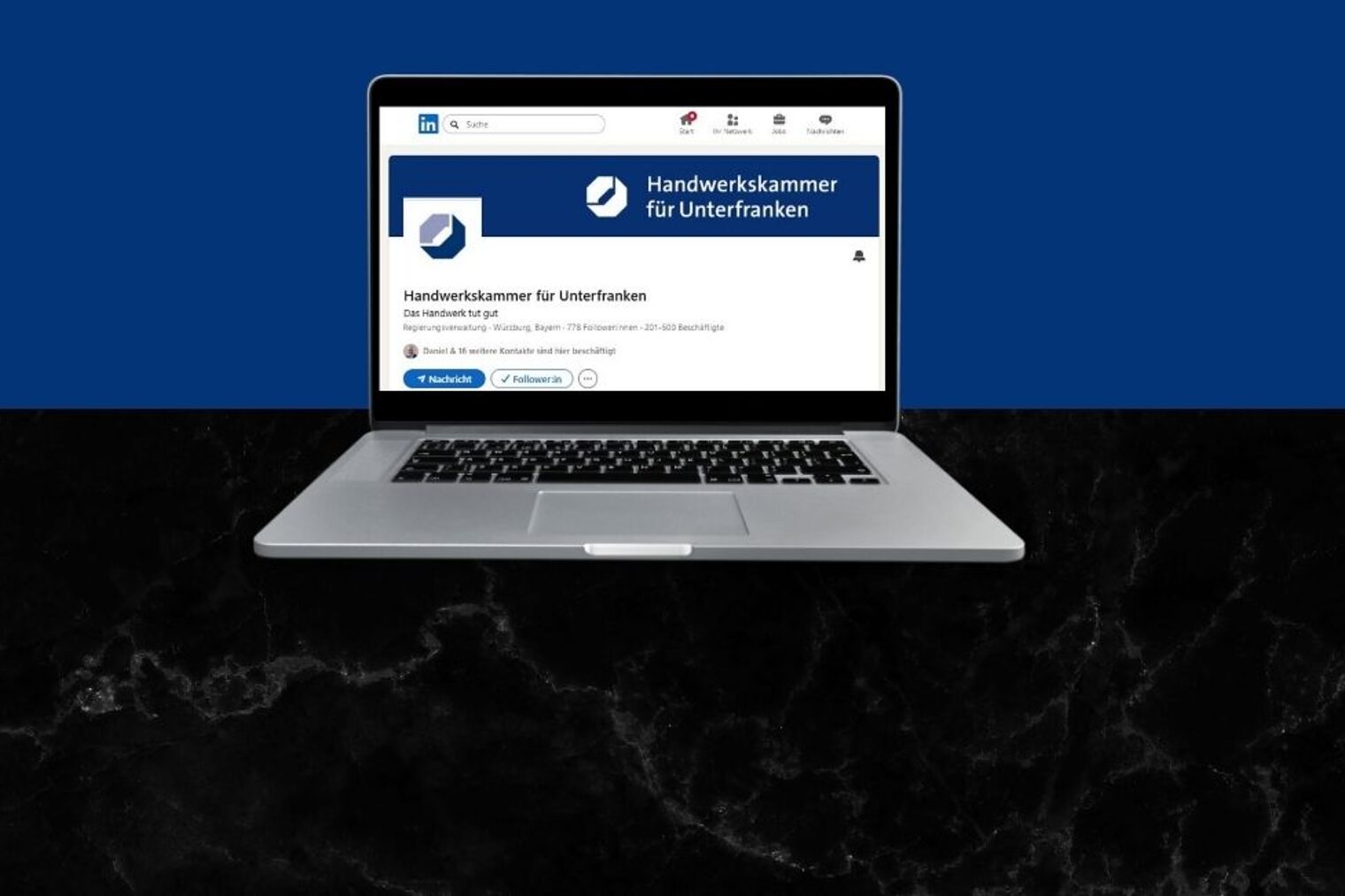 Man sieht einen Laptop. Auf dem Bildschirm sieht man die LinkedIn-Seite der Handwerkskammer für Unterfranken