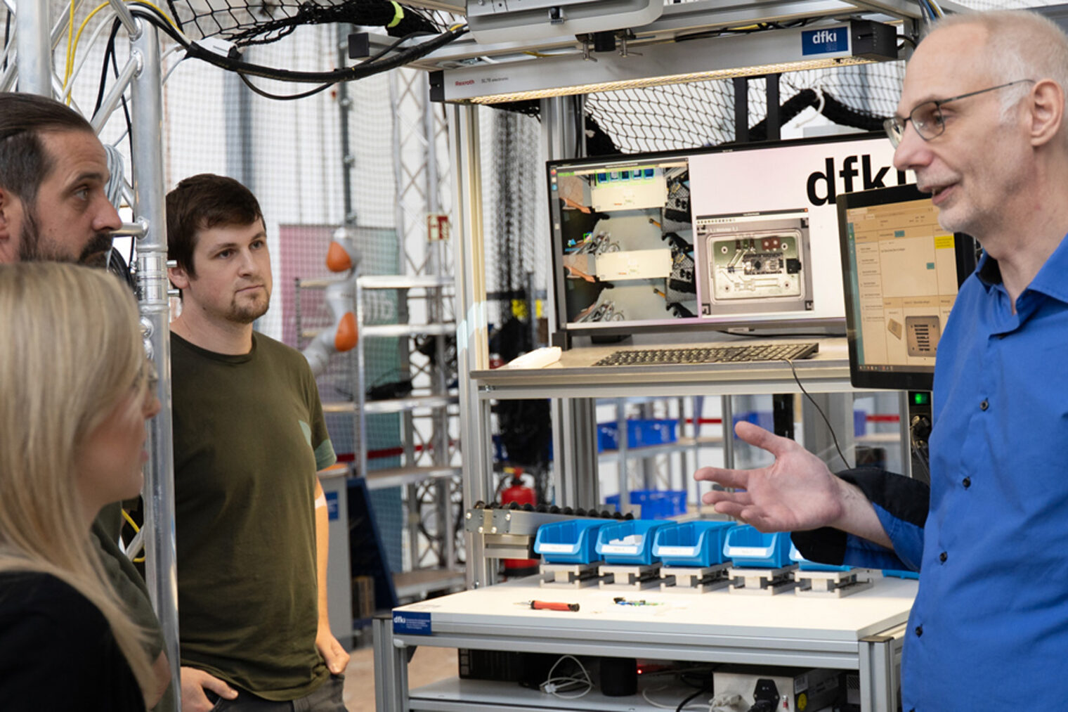 Labor mit Computer und Tracking-Ki-Aufbau, eine Person erklärt drei anderen etwas