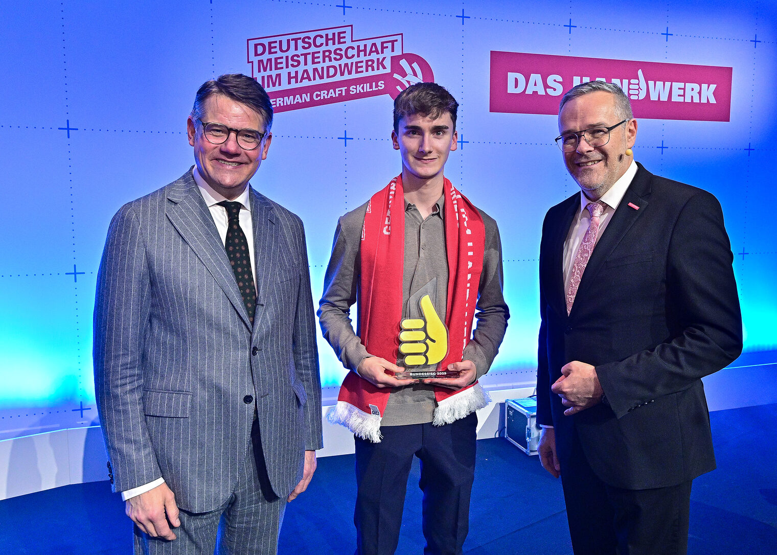 Gruppenfoto drei Personen auf Bühne