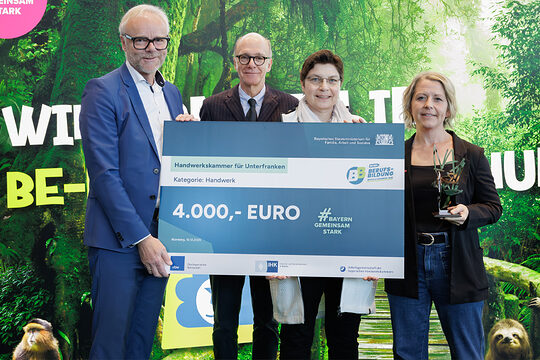 Gruppenfoto vier Personen mit Scheck und Aufschrift 4.000 Euro