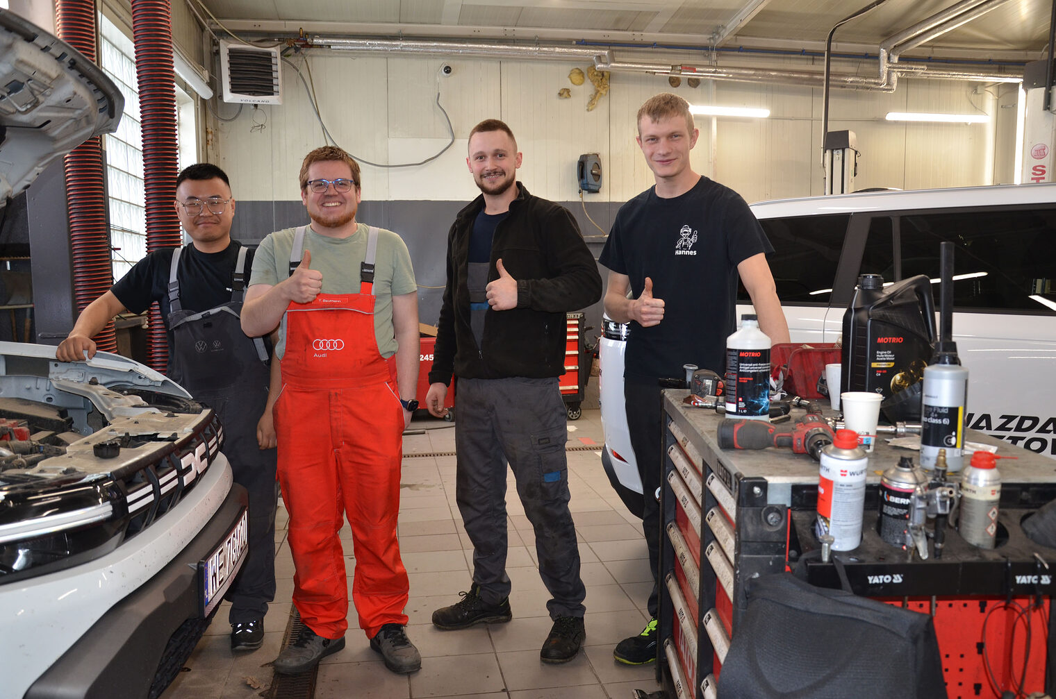 Gruppenbild mit Junghandwerkern und Betriebsinhabern in Kfz-Werkstatt