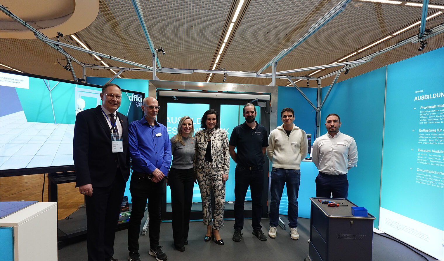 Gruppenfoto sieben Personen an Messestand