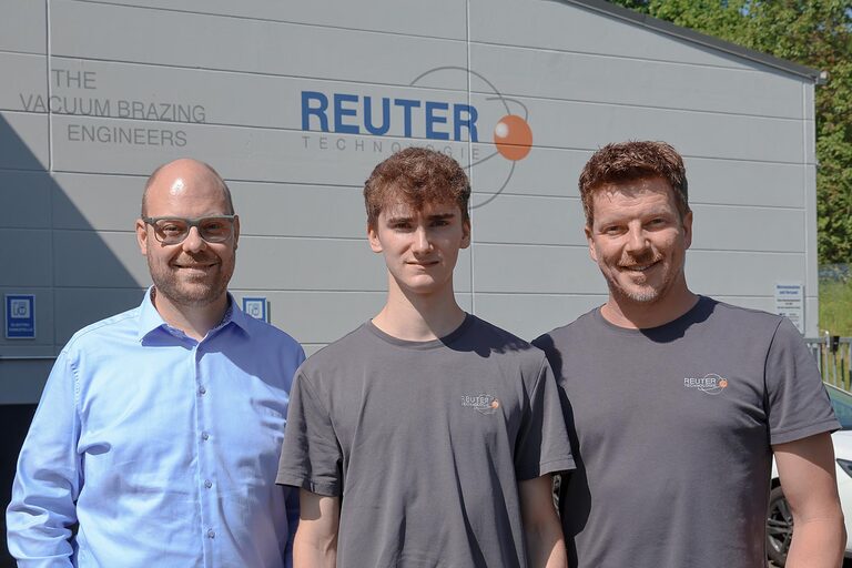 Gruppenfoto vor Betriebsstandort drei Personen